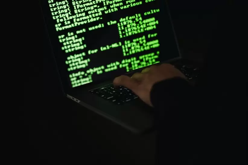 Hacker De Cultivos Escribiendo En La Computadora Portátil Con Información En La Pantalla