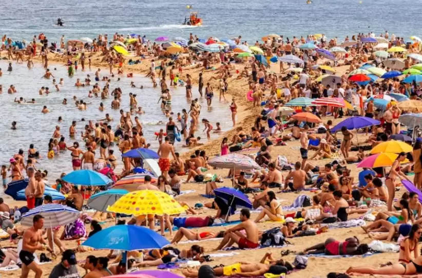 Multitudes de turistas en la playa de la Barceloneta, Barcelona, España
