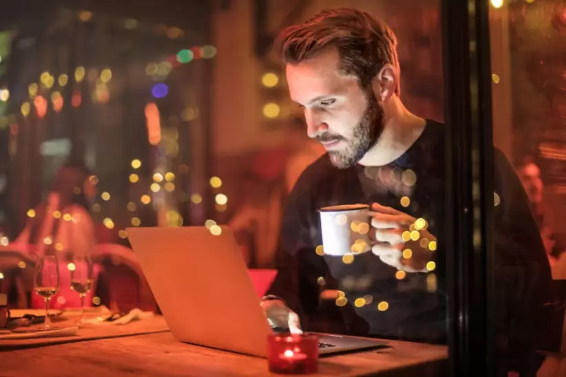 Hombre Sujetando La Taza Delante De La Computadora Portátil