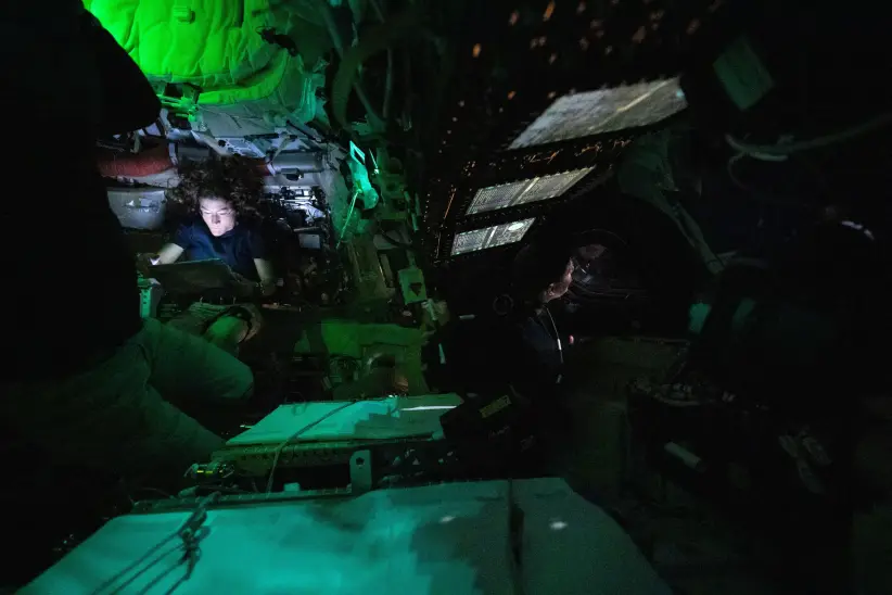 La astronauta Christina Koch leyendo en la tenue luz de la cápsula Orion. 