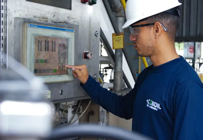 Ingeniero que utiliza el panel de control en una instalación industrial para garantizar la eficiencia operativa. (Foto: Pexels)