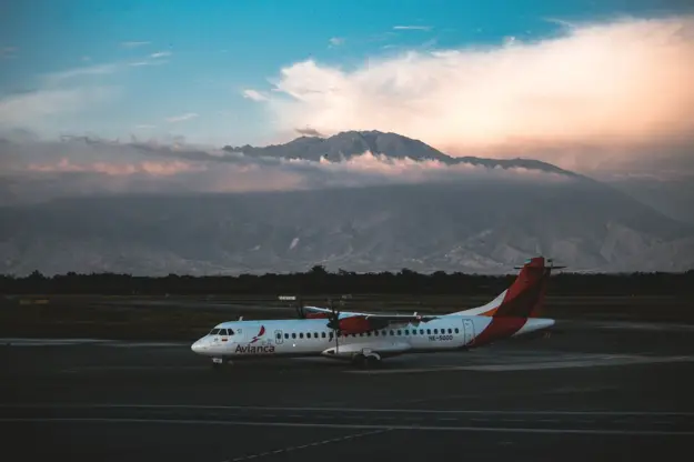 Avión de Avianca estacionado en la pista con majestuosas montañas de fondo bajo un cielo espectacular. (Foto: Pexels)